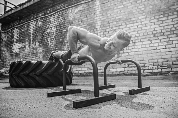 Starker sportlicher fröhlicher positiver Mann macht Presseübungen mit Planke im Freien — Stockfoto