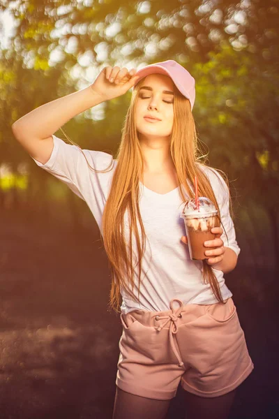 Stijlvolle jonge vrouw met drank in de zomer — Stockfoto