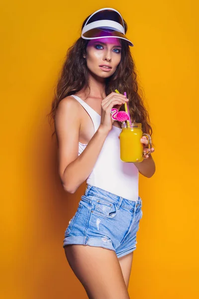 Sexy Woman in white swimsuit and blue jeans shorts, trendy visor holding beverage — Stock Photo, Image