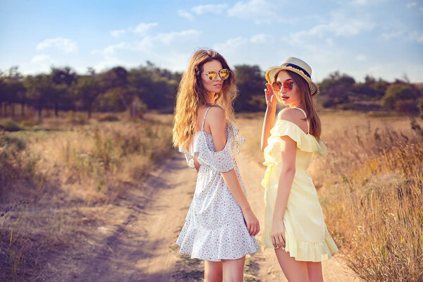 two pretty girlfriends in summer dresses