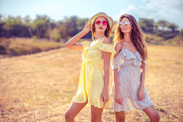 two pretty girlfriends in summer dresses