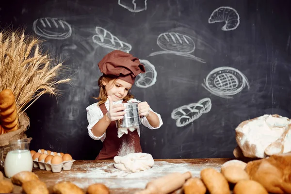 Little girl kneading dough at table — Stock Photo, Image