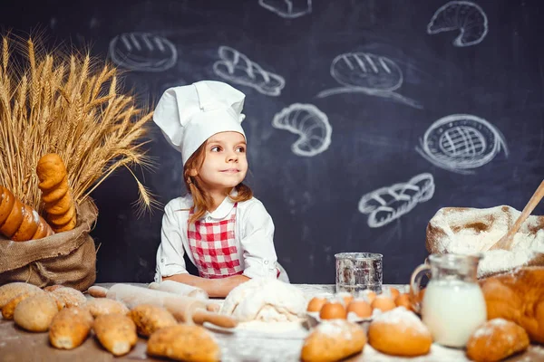 Menina adorável em chapéu de chef fazendo massa — Fotografia de Stock