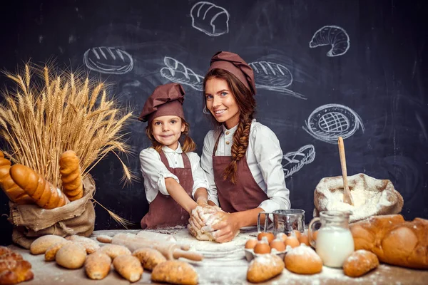 Kvinna och flicka att göra bakverk tillsammans — Stockfoto