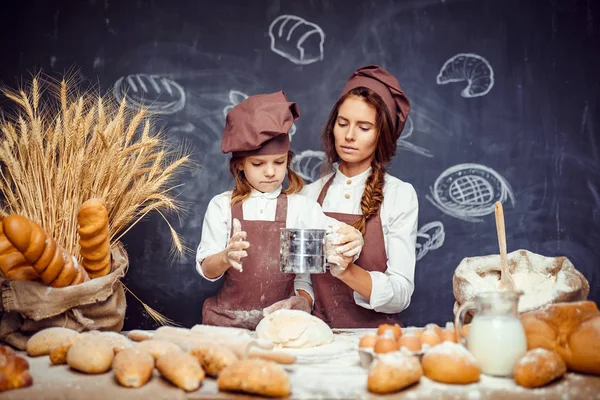 Kvinna och flicka att göra bakverk tillsammans — Stockfoto