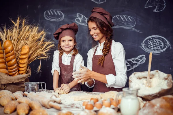 Kvinna och flicka att göra bakverk tillsammans — Stockfoto