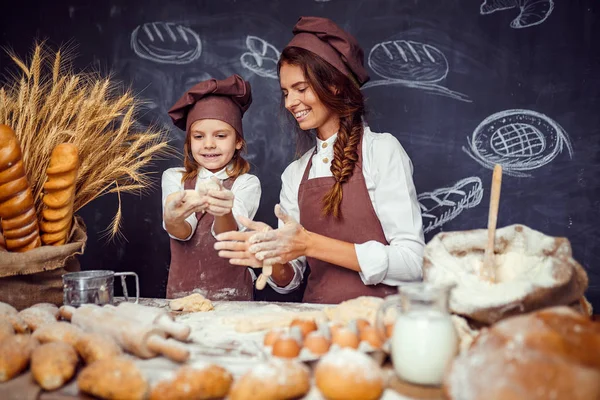 Kvinna och flicka att göra bakverk tillsammans — Stockfoto