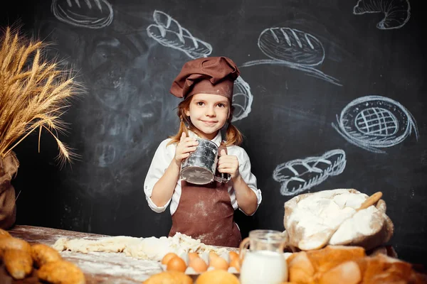 Menina amassando massa de farinha à mesa — Fotografia de Stock