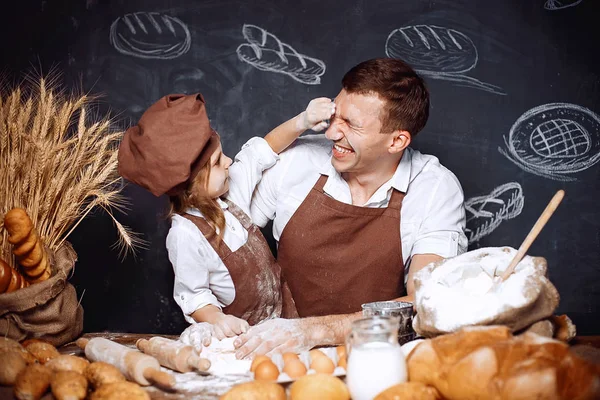 Смеющийся мужчина с дочерью пекут хлеб — стоковое фото