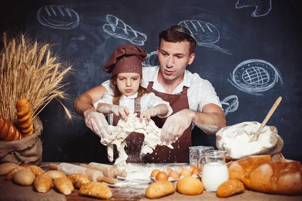 Игривый мужчина с дочерью пекут хлеб — стоковое фото