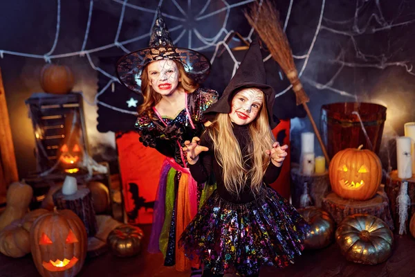 İki sevimli komik kız kardeş tatil kutlamak. Neşeli çocuklar karnaval kostümleri Cadılar Bayramı için hazır. — Stok fotoğraf