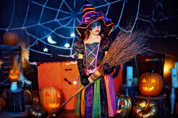 Portrait d'une mignonne petite fille en costume de sorcière avec balai magique . — Photo