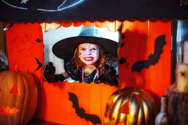 Feliz Halloween. Una niña hermosa en un disfraz de bruja celebra con calabazas — Foto de Stock