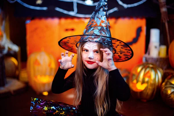 Feliz Dia das Bruxas. Uma menina bonita em um traje de bruxa celebra com abóboras — Fotografia de Stock