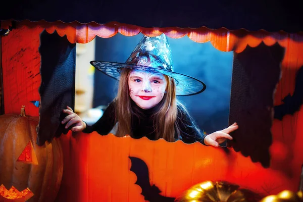 Feliz Dia das Bruxas. Uma menina bonita em um traje de bruxa celebra com abóboras — Fotografia de Stock
