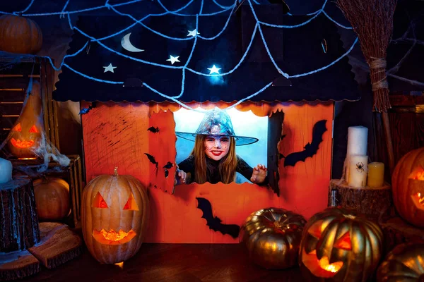 Feliz Halloween. Una niña hermosa en un disfraz de bruja celebra con calabazas — Foto de Stock