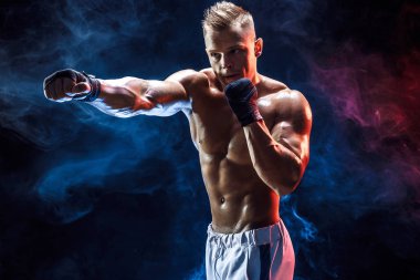Boks eldivenli kaslı üstsüz dövüşçü.
