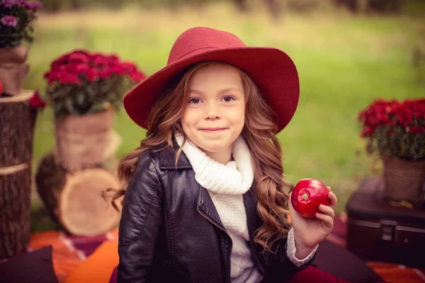 Usmívající se dítě s červená jablka, sedí na podzim park — Stock fotografie