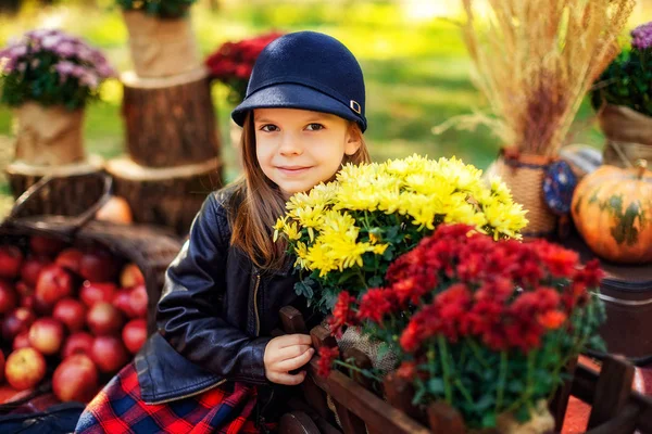 Niño sonriente con cesta de manzanas rojas sentado en el parque de otoño — Foto de Stock