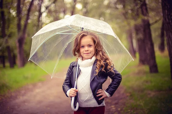 Szczęśliwe dziecko śmieszne z parasol w deszczu. — Zdjęcie stockowe