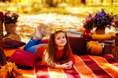 Sepeti sonbahar parkta oturan kırmızı elma ile gülümseyen çocuk