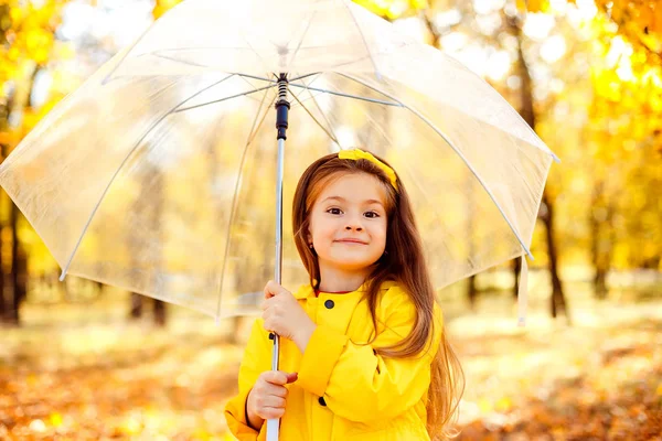 Счастливая девочка с пупсом и резиновыми сапогами на осенней прогулке — стоковое фото