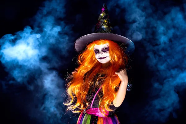 Duman karanlık bir arka plan üzerinde bir cadı kostüm güzel kız. — Stok fotoğraf