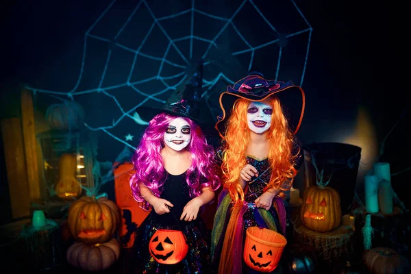 Dvě roztomilé směšné sestry slaví svátek. Veselé děti v karnevalových kostýmů připraveni na Halloween. — Stock fotografie