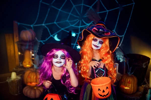 Duas irmãs engraçadas e fofas celebram o feriado. Crianças alegres em trajes de carnaval prontos para o Halloween . — Fotografia de Stock