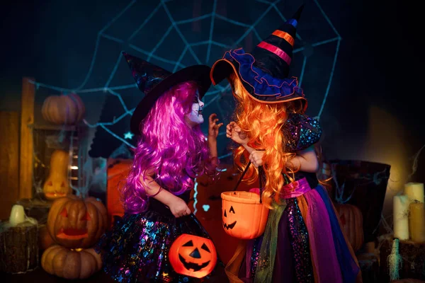 Dos lindas hermanas divertidas celebran la fiesta. Niños alegres en trajes de carnaval listos para Halloween . — Foto de Stock