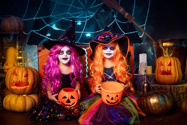 Duas irmãs engraçadas e fofas celebram o feriado. Crianças alegres em trajes de carnaval prontos para o Halloween . — Fotografia de Stock