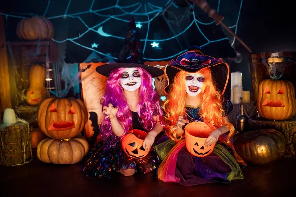Duas irmãs engraçadas e fofas celebram o feriado. Crianças alegres em trajes de carnaval prontos para o Halloween . — Fotografia de Stock