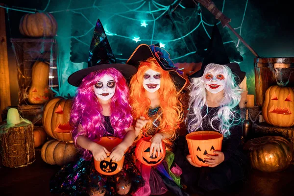 Tres lindas hermanas divertidas celebran la fiesta. Niños alegres en trajes de carnaval listos para Halloween . — Foto de Stock