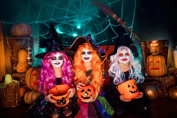 Tres lindas hermanas divertidas celebran la fiesta. Niños alegres en trajes de carnaval listos para Halloween . — Foto de Stock