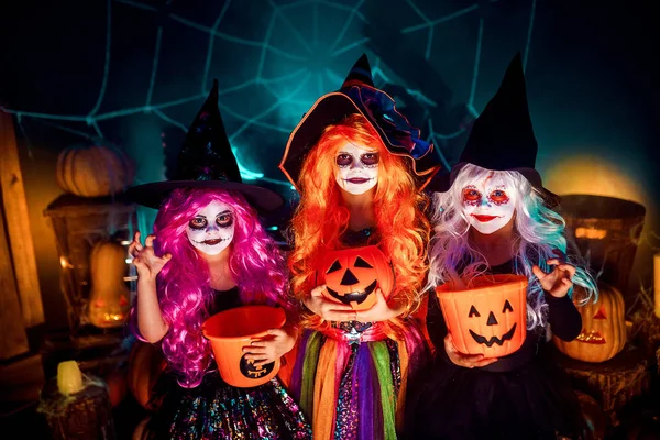 Tři roztomilé směšné sestry slaví svátek. Veselé děti v karnevalových kostýmů připraveni na Halloween. — Stock fotografie