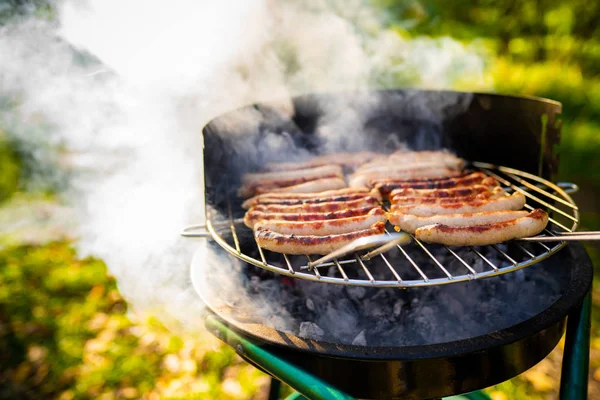 Barbacoa con salchichas ardientes en la parrilla —  Fotos de Stock