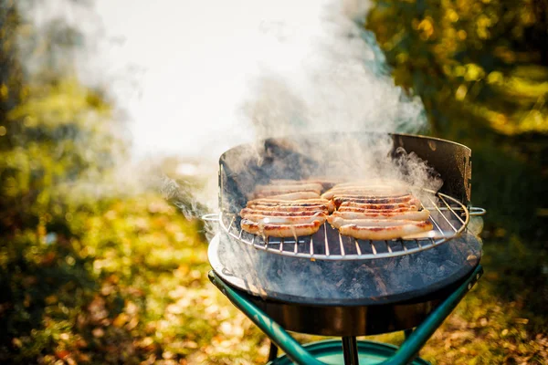 Barbacoa con salchichas ardientes en la parrilla —  Fotos de Stock