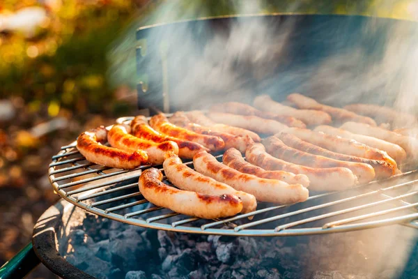 Barbacoa con salchichas ardientes en la parrilla —  Fotos de Stock