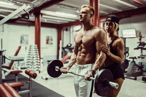 Young man and a woman team training with dumbbells