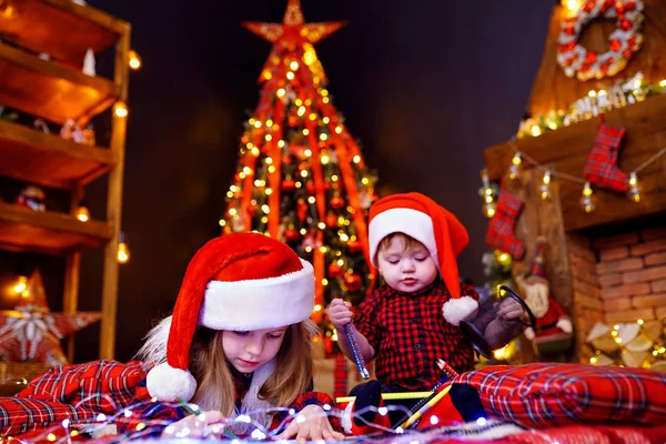 Rolig tjej i Santa hatt skriver brev till Santa och brodern liitle — Stockfoto