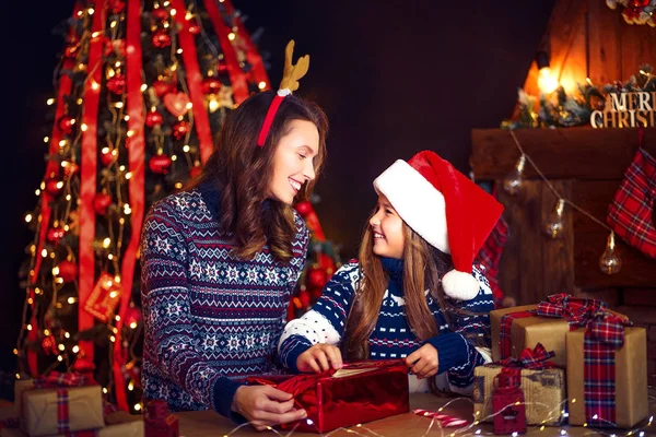 En lycklig familj mamma och barn packa julklappar — Stockfoto