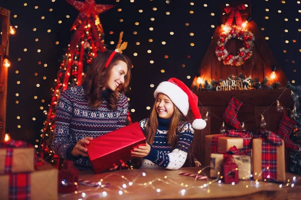 Щаслива сім'я мати і дитина упаковують різдвяні подарунки — стокове фото