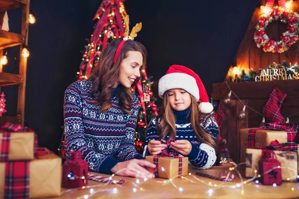 En lycklig familj mamma och barn packa julklappar — Stockfoto