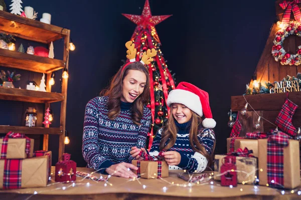 En lycklig familj mamma och barn packa julklappar — Stockfoto