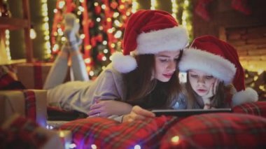 Anne ve kızı yatak ve İzle Noel süsleri tablet yatan