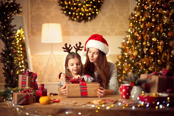 En lycklig familj mamma och barn packa julklappar — Stockfoto