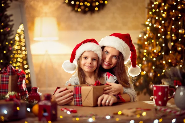 En lycklig familj mamma och barn packa julklappar — Stockfoto