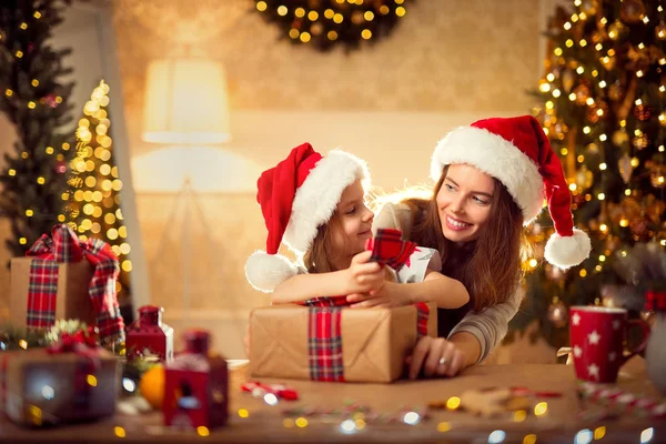 Щаслива сім'я мати і дитина упаковують різдвяні подарунки — стокове фото