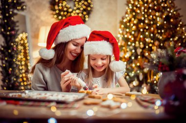 Mutlu Noeller ve mutlu tatiller. Anne ve kızı Noel kurabiye pişirme.