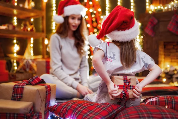 Glad mamma och hennes söta dotter flicka utbyter gåvor. Kärleksfull familj med presenterar i jul rum. — Stockfoto